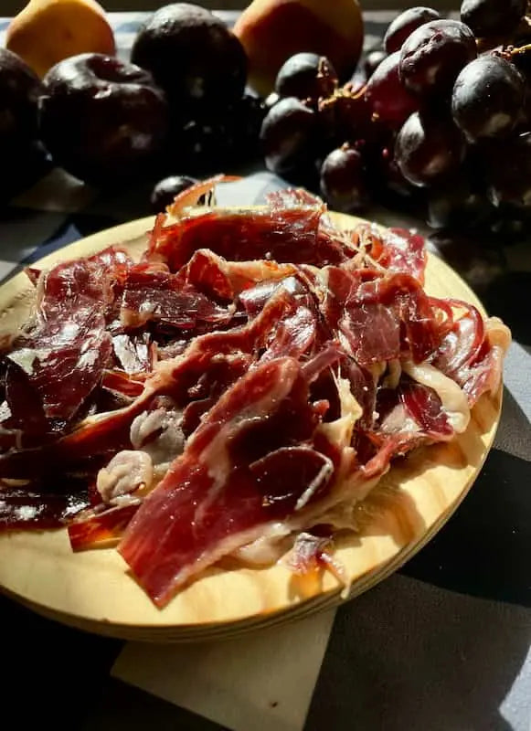 jamón ibérico plato madera uvas