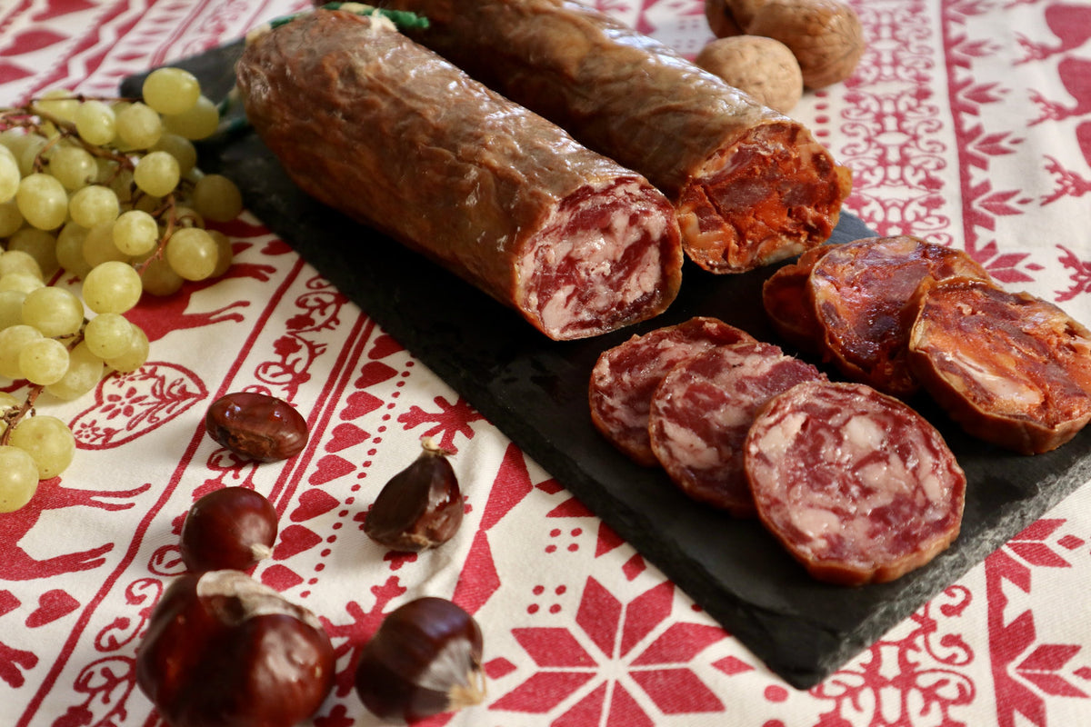 Salchichón y chorizo cular ibéricos de bellota enteros y en rodajas sobre pizarra